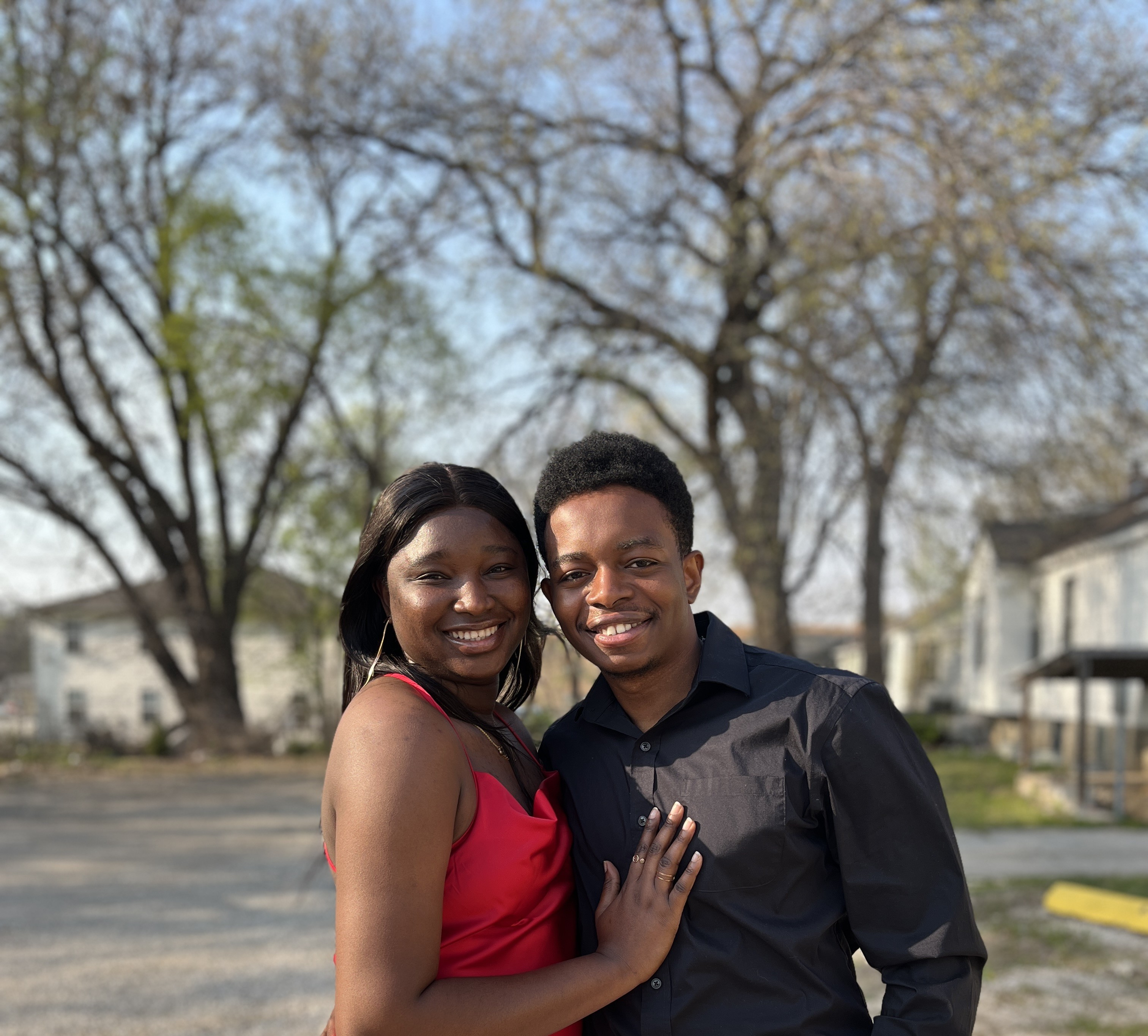 Paschal and Maryanne dressed in red and black, smiling together