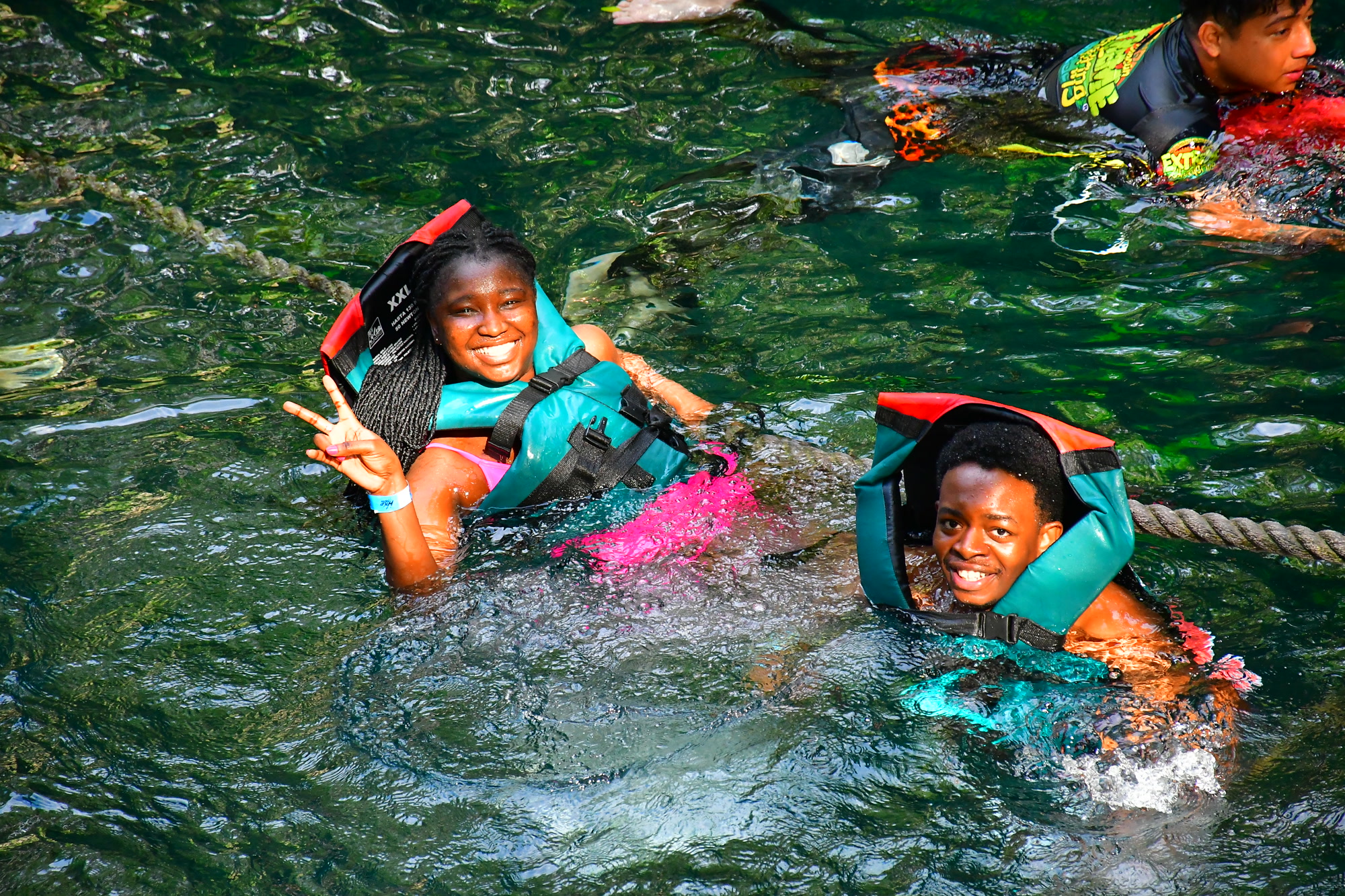 Paschal and Maryanne smiling together while swimming in life jackets